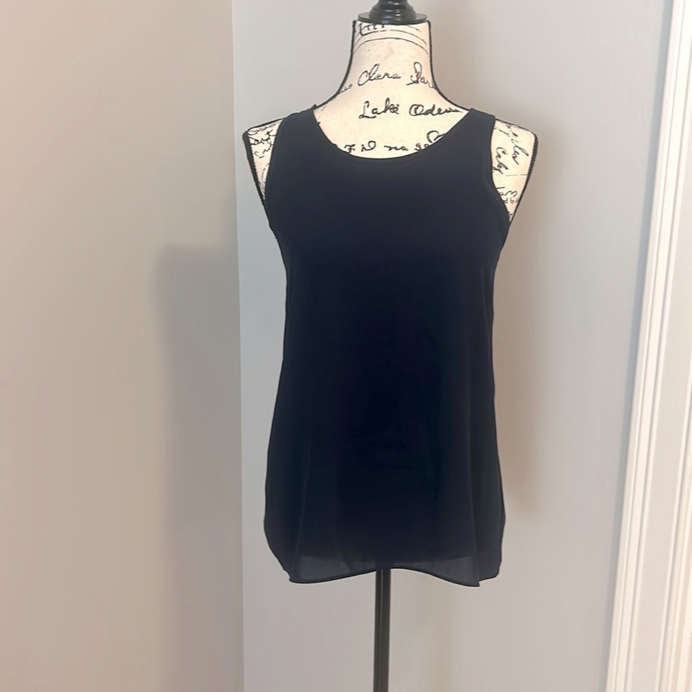 Navy sleeveless blouse, flares out and ties in back. Tuck in or out, size XS